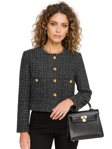 Woman wearing a black tweed jacket with gold buttons, holding a black handbag on a white background